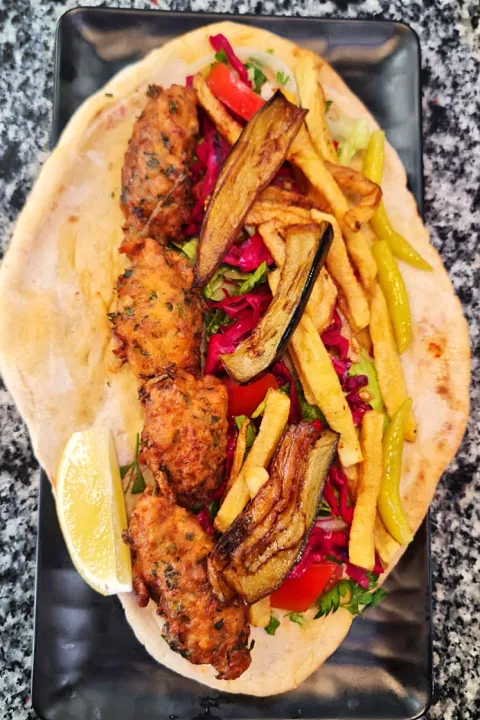 Pide üzerinde ökçe, patlıcan ve patates kızartması