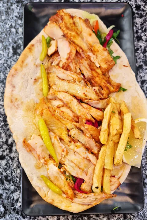 Pide ekmeğinde tavuk döner, patates kızartması ve biber turşusu